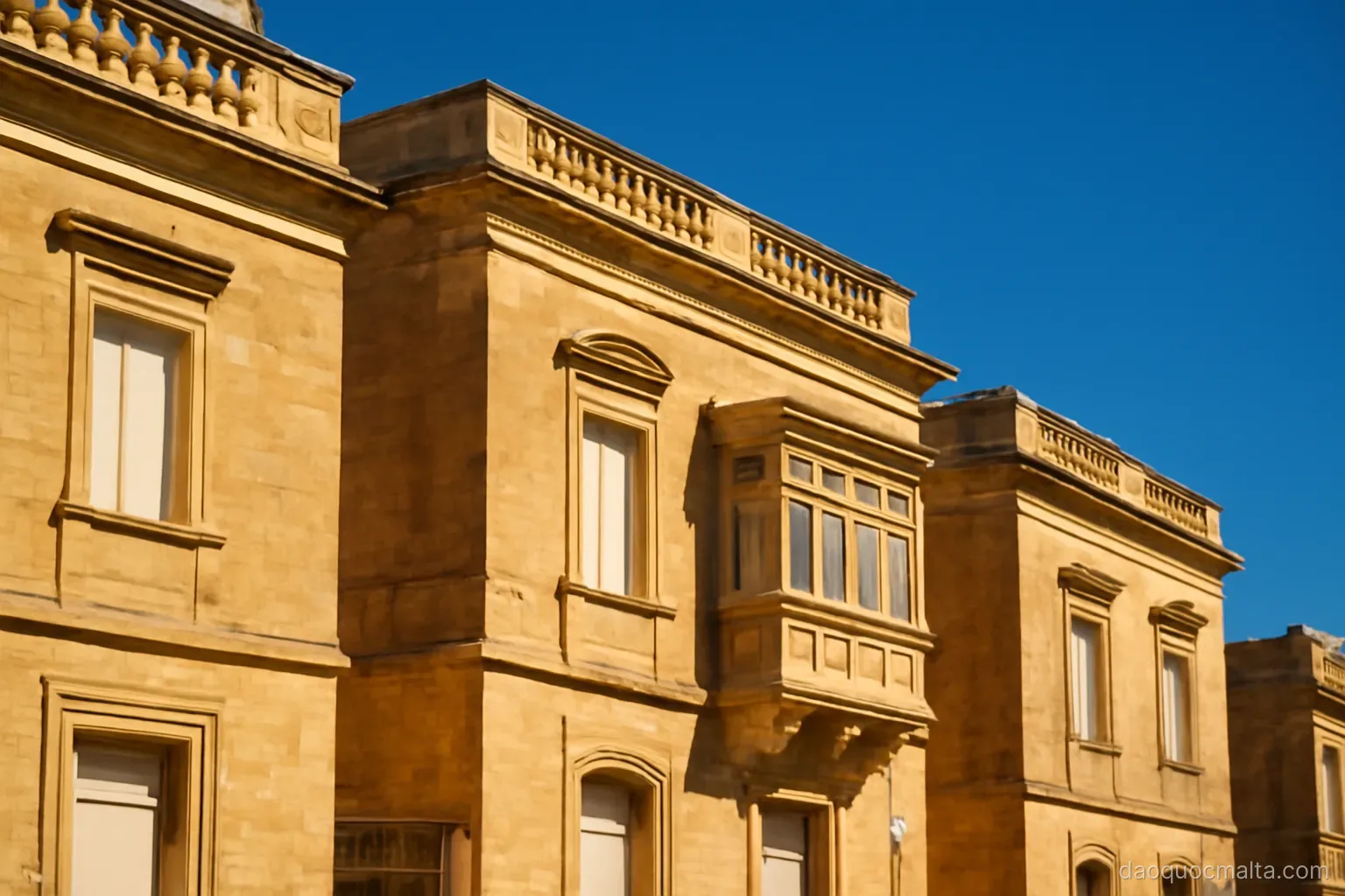 bright sunlight on golden stone buildings under a cloudless deep blue sky
